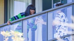 Petenis Amerika Serikat, Venus Williams, melihat hasil foto saat bersantai di balkon hotel di Adelaide, Australia, Jumat (22/1/2021). Venus Williams melakukan karantina selama dua minggu sebelum mengikuti ajang Australia Terbuka 2021. (AFP/Brenton Edwards)