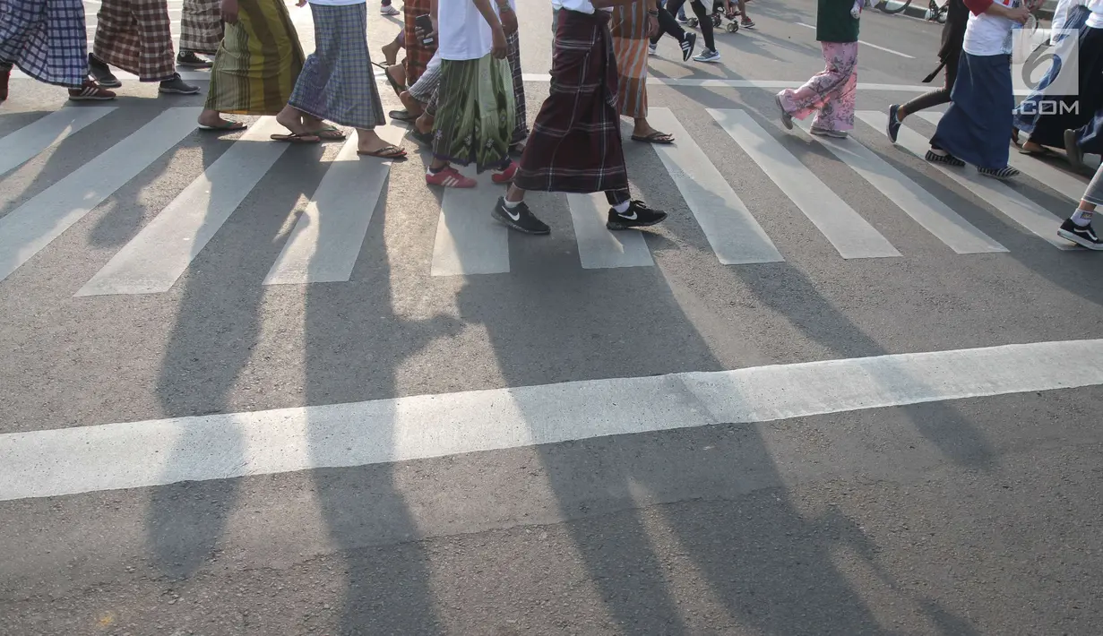 Para santri mengikuti jalan sehat sarungan di kawasan Monas, Jakarta, Minggu (30/9). Jalan sehat tersebut dilakukan dalam rangka memperingati Hari Santri yang jatuh pada 22Oktober mendatang. (Liputan6.com/Angga Yuniar)