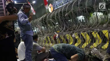 Peserta aksi massa Gerakan Nasional Kedaulatan Rakyat melakukan salat maghrib saat unjuk rasa di depan Gedung Bawaslu, Jalan MH Thamrin, Jakarta, Selasa (21/5/2019). Dalam aksinya, mereka Bawaslu memeriksa hasil Pemilu 2019 yang dinilai banyak terdapat kecurangan. (Liputan6.com/Helmi Fithriansyah)