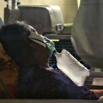 Seorang pasien virus corona COVID-19 terlihat menggunakan oksigen di unit perawatan intensif (ICU) di sebuah rumah sakit di Lhokseumawe, Aceh, Selasa (7/7/2021). Indonesia memperluas pembatasan untuk memerangi gelombang virus corona COVID-19 yang mematikan. (Azwar Ipank/AFP)