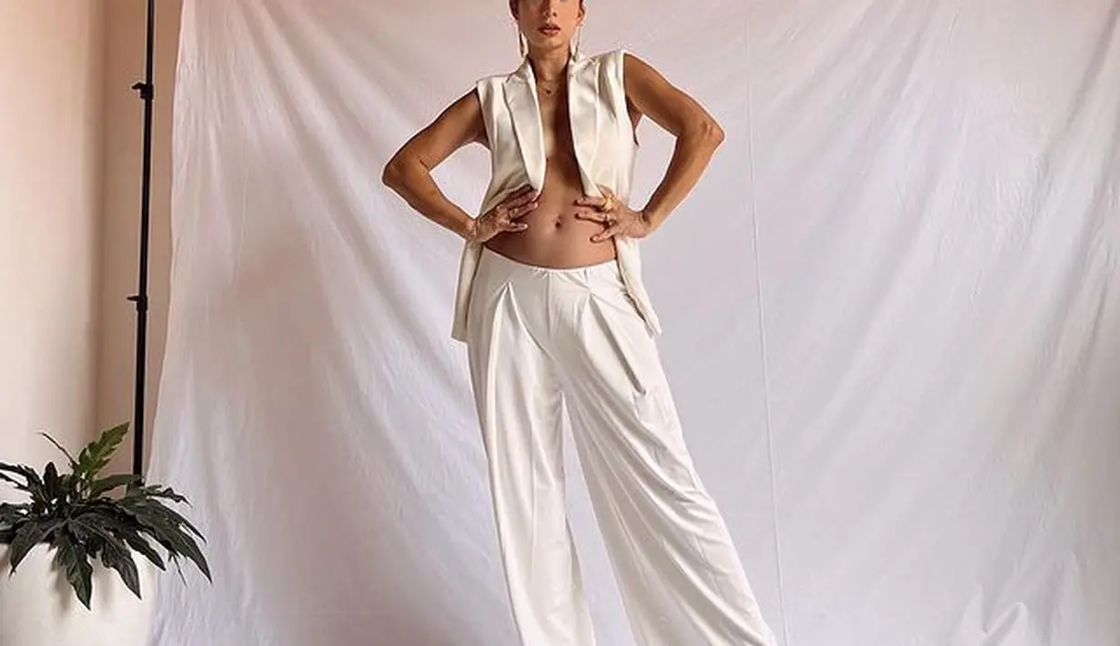 Jennifer Bachdim tampil percaya diri dengan outfit minimalis. Ia mengenakan long vest berwarna putih dan kulot berwarna senada. (instagram/jenniferbachdim)