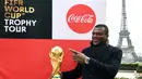 Mantan bek Prancis, Marcel Desailly berpose dengan trofi Piala Dunia dengan latar menara Eiffel selama FIFA World Cup Trophy Tour di Paris (20/3). Piala Dunia 2018 diselenggarakan 14 Juni dan 15 Juli 2018 di Rusia. (AFP Photo/Franck Fife)