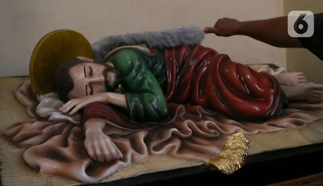 Pekerja membersihkan patung di Gereja Katedral, Jakarta, Kamis (21/12/2023). (Liputan6.com/Herman Zakharia)