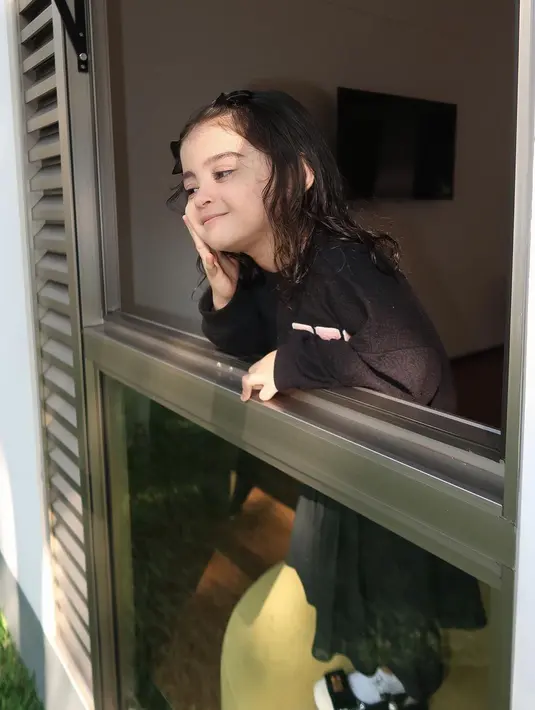 Ia mengenakan atasan lengan panjang berwarna hitam yang dipadukan rok rempel warna senada.  [@marginw]