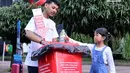 Seorang anak membuang sampah botol plastik sampah di acara Plastic Reborn, CFD Senayan, Jakarta, Minggu (4/3). Plastic Reborn merupakan program yang didesain untuk menginspirasikan perubahan perilaku kepada generasi muda. (Liputan6.com/Pool/Rizky)
