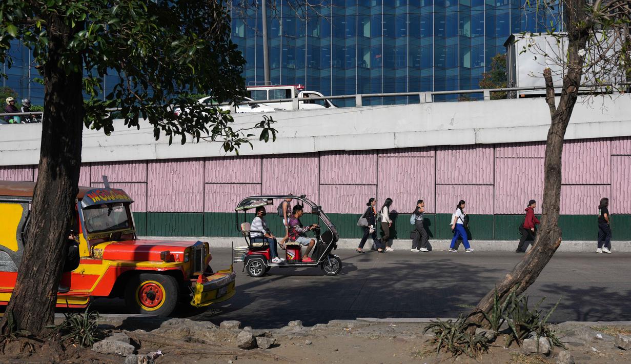 Diketahui, untuk memenuhi kebutuhan domestik, Filipina sangat bergantung pada impor minyak dari kawasan Timur Tengah. Tampak dalam foto, para penumpang berjalan di sepanjang jalan di kota Pasay, Filipina, pada Senin, 23 Maret 2026. (AP Photo/Aaron Favila)