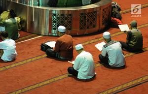 Umat muslim membaca Al-Quran secara berjamaah pada hari ke-28 bulan suci Ramadan di Masjid Istiqlal, Jakarta, Selasa (12/6). Sejumlah umat muslim meningkatkan ibadah mereka dengan melakukan itikaf di Masjid Istiqlal. (Liputan6.com/Helmi Fithriansyah)