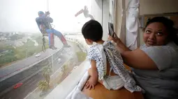 Petugas pembersih kaca berkostum superhero bergelantungan di luar jendela untuk menghibur pasien anak di rumah sakit anak-anak di Guadalupe, Meksiko, 30 April 2019. Pemandangan tidak biasa ini membuat para pasien anak di rumah sakit tersebut terkesima. (REUTERS/Daniel Becerril)