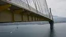 Seorang koreografer dan penari "ekstrem", Katerina Soldatou melakukan tarian di bawah jembatan Rio-Antirio, Yunani selatan, Senin (12/3).  Jembatan ini merupakan jembatan bentang kabel terpanjang di dunia. (AP Photo/Petros Giannakouris)