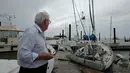 Seorang pria melihat perahu layar yang rusak akibat dilanda badai Harvey, Texas (26/8). Badai Harvey ini tercatat sebagai badai paling kuat yang melanda AS dalam lebih dari sepuluh tahun. (AP Photo / Charlie Riedel)