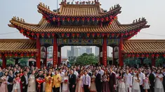 Pasangan pengantin baru keturunan Tionghoa  berfoto bersama seusai acara pernikahan massal di Kuil Thean Hou, Kuala Lumpur, Senin (9/9/2019). Upacara pernikahan massal diadakan untuk 99 pasangan pada hari kesembilan bulan kesembilan yang dianggap sebagai tanggal keberuntungan. (Mohd RASFAN / AFP)