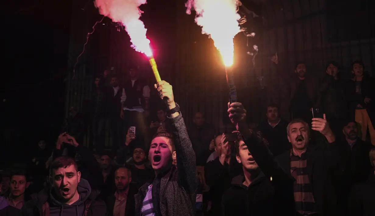 Orang-orang meneriakkan slogan-slogan saat protes di luar konsulat Swedia di Istanbul, Turki, Minggu (22/1/2023). Pembakaran Al-Qur'an dilakukan seorang politisi bernama Rasmus Paludan. (AP/Khalil Hamra)