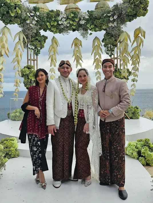 Sheila Dara juga mendampingi sang suami menjadi bridesman. Ia tampil cantik dalam balutan atasan tanpa lengan bersiluet kebaya berwarna merah bata. Penampilan semakin manis dengan kain batik hitam jumputan, dan selendang hitam polos. [@vidialdiano]