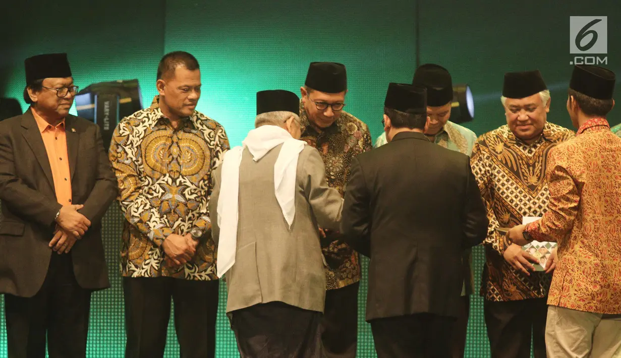 Ketua MUI KH Ma'ruf Amin memberikan buku Penggerak Ulama Pelindung Umat kepada sejumlah pejabat tinggi dan tokoh pada acara Milad MUI ke-42 dan Anugerah Syiar Ramadan 2017 di Jakarta, Kamis malam (26/7). (Liputan6.com/Herman Zakharia)
