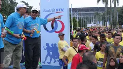 Direktur Utama Bank BTN Maryono (topi berkacamata hitam) usai melepas ribuan peserta home run in harmony di Senayan, Jakarta, Minggu (21/2). (Liputan6.com/Angga Yuniar)