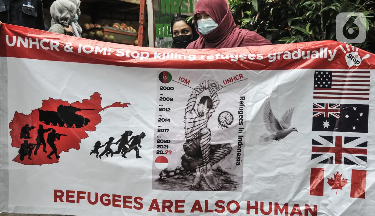 Pencari suaka asal Afghanistan membentangkan poster tuntutan di depan Kantor UNHCR, Jakarta, Senin (15/11/2021).  Ratusan pencari suaka tersebut menuntut segera dipindahkan ke negara ketiga yang terbebas dari konflik perang setelah lebih 10 tahun mengungsi di Indonesia. (merdeka.com/Iqbal S Nugroho)