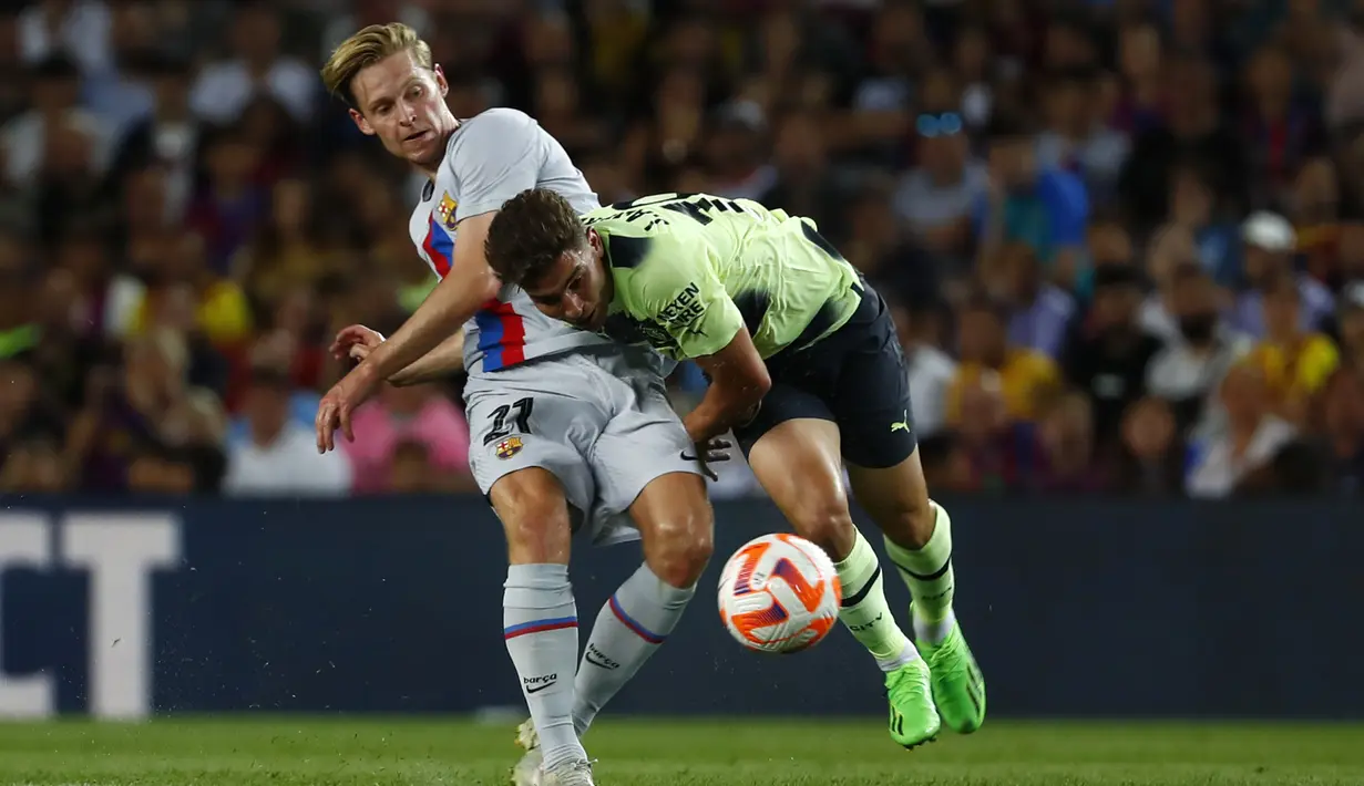 Gelandang Barcelona Frenkie de Jong berebut bola dengan penyerang Manchester City Julian Alvarez pada sebuah laga amal di Stadion Camp Nou, Kamis (25/8/2022) dini hari WIB. Laga Barcelona vs Man City berjalan ketat, skor akhir sama kuat 3-3. (AP Photo/Joan Monfort)