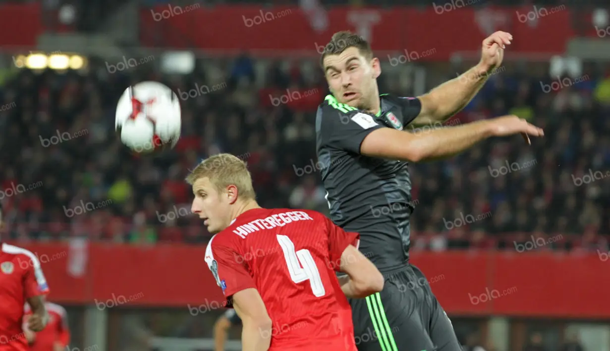 Striker Timnas Wales, Sam Vokes (kanan), berduel dengan bek Austria, Hinteregger. (Bola.com/Reza Khomaini)