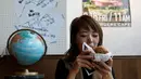 Seorang pengunjung menikmati Mrs. Burger di J.S. Burgers Cafe, Tokyo, Jepang, (7/10). Memeriahkan pilpres AS, kafe di Tokyo ini membuat menu  baru yang unik yakni Mr. dan Mrs. Burger. (REUTERS/Megumi Lim)