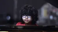 Pianis belia asal Indonesia, Joey Alexander saat latihan bermain piano di Prancis, 10 Agustus 2015. Pianis jazz berusia 12 tahun itu masuk nominasi Grammy Awards 2016.  (AFP PHOTO/PASCAL Pavani)