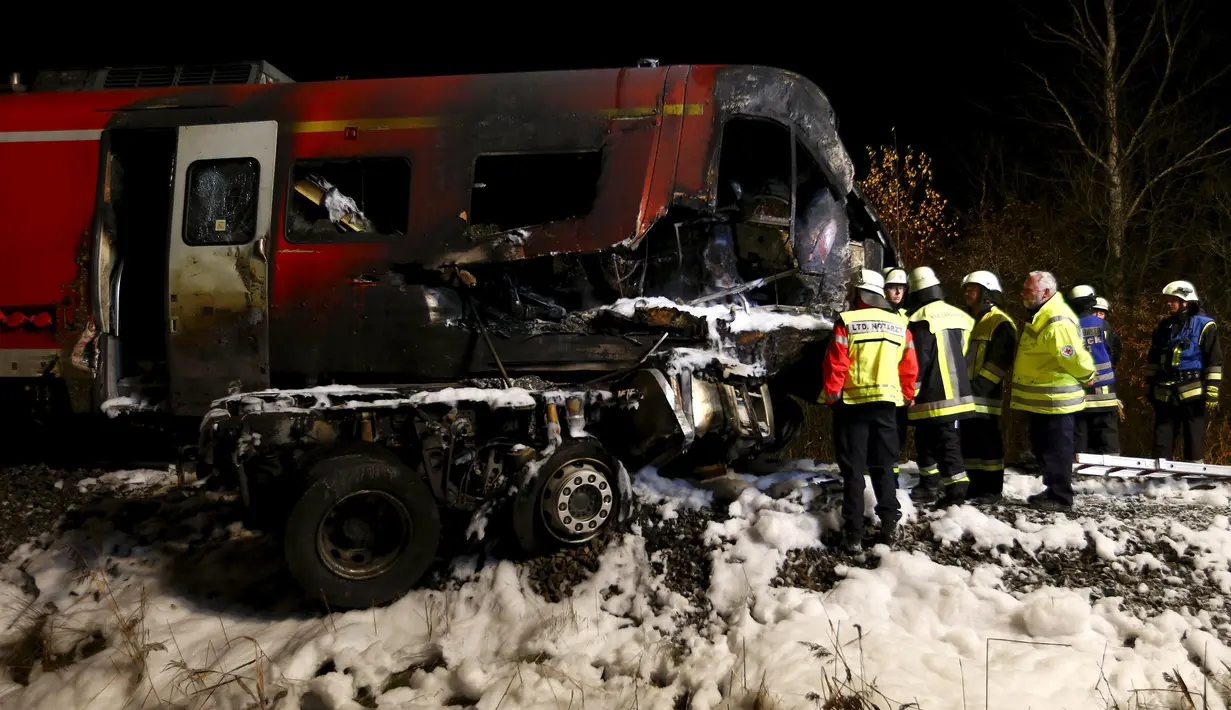 Sejumlah petugas pemadam berada di lokasi kecelakaan kereta penumpang dengan truk milter di persimpangan kereta api di Freihung, Jerman, Kamis (5/11). Sedikitnya satu orang tewas dan beberapa lainnya terluka. (REUTERS / Michaela Rehle)
