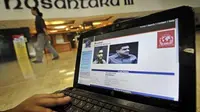 Seorang wartawan menunjukkan situs Interpol yang memuat pengumuman pencarian Muhammad Nazarudin tersangka kasus suap Kemenpora, di Kompleks Parlemen Senayan, Jakarta. (Antara)