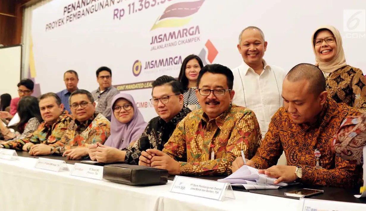 Dirut Jasa Marga Desi Arryani menyaksikan Pemimpin Divisi Korporasi & Komersial Bank BJB Dicky Syahbandinata menandatangani perjanjian kredit sindikasi Jasa Marga terkait pembangunan ruas Tol Cikampek II, Jakarta, Selasa (31/7). (Merdeka.com/Arie Basuki)