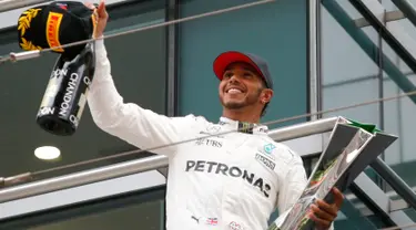 Pembalap Mercedes, Lewis Hamilton bersorak sambil memegang trofi Grand Prix (GP) China di Sirkuit Internasional Shanghai, Minggu (9/4). Hamilton finis pertama dengan catatan waktu 1 jam 37 menit 36,158 detik.(AP Photo/Toru Takahashi)