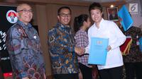 Menpora Imam Nahrawi (tengah) bersama Kepala BKN, Bima Haria Wibisana menyerahkan SK CPNS kepada pebulutangkis Indonesia, Liliyana Natsir di Wisma Kemenpora, Jakarta, Selasa (2/4). 286 atlet berprestasi menerima SK pengangkatan sebagai CPNS di lingkungan Kemenpora. (Liputan6.com/Helmi Fithriansyah)