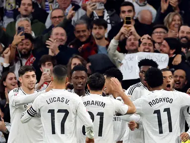 Penyerang Real Madrid, Kylian Mbappe (kanan) merayakan golnya saat laga pekan ke-18 La Liga 2024/2025 melawan Sevilla FC di Stadion Santiago Bernabeu, Madrid, 22 Desember 2024. (OSCAR DEL POZO/AFP)