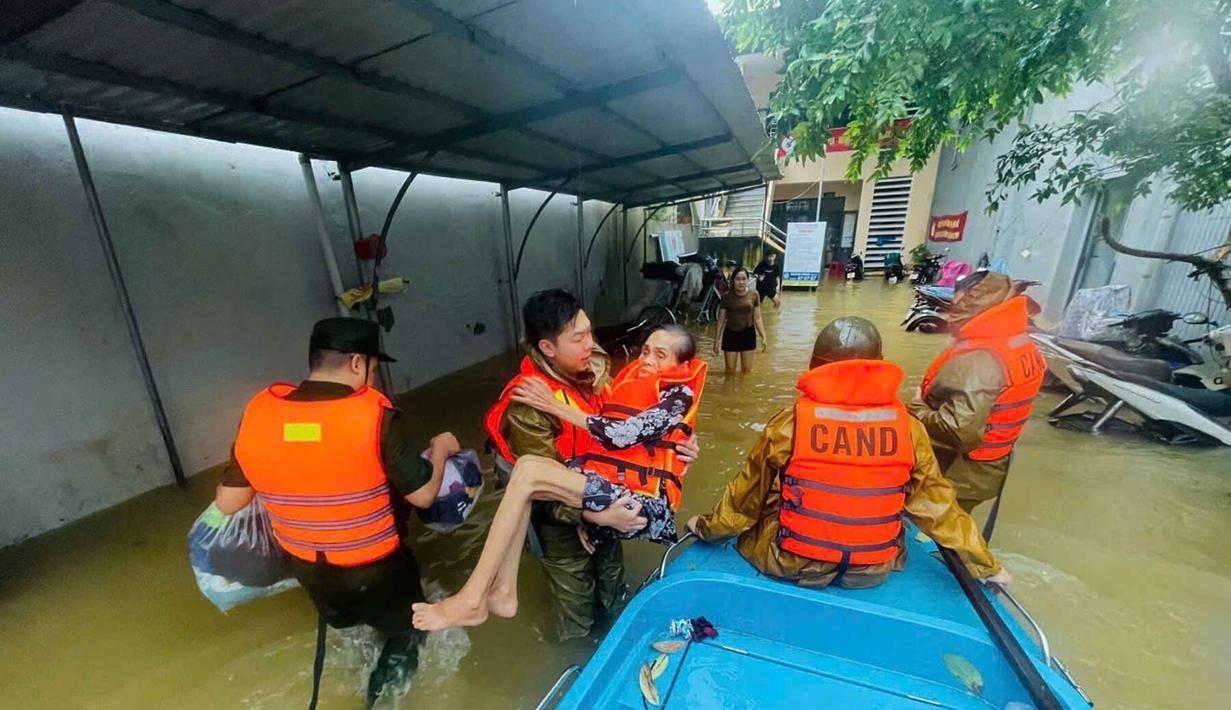 Polisi mengevakuasi warga setempat dari banjir di Hue, Vietnam, Selasa, 28 Oktober 2025. Lebih dari 8.600 orang di wilayah tengah Vietnam telah dievakuasi ke sekolah dan gedung-gedung umum sejak Sabtu (25/10/2025) karena ancaman banjir besar dan tanah longsor. (Nguyen Van Ly/VNA via AP)