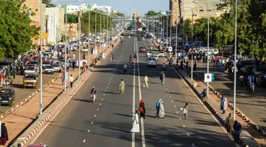 Orang-orang melintasi jalanan di Niamey, Niger (10/7/2019). Niamey adalah ibu kota sekaligus kota terbesar Niger. Penduduknya berjumlah 800,000 jiwa (2000) dengan luas wilayah 670 km².  (AFP Photo/Issouf Sanogo)