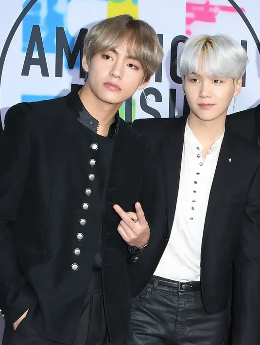 Dua personel boyband Korea Selatan, Bangtan Boys alias BTS berpose di karpet merah ajang American Music Awards 2017 di Los Angeles, Minggu (19/11). Meski tampil hampir serupa, ketujuh anggota BTS tentu tidak terlihat sama. (Mark Ralston/AFP)