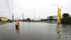 Para pekerja mencoba mensurvei tanah di bawah air banjir di Auckland, Selandia Baru, Rabu (1/2/2023). Peringatan hujan lebat untuk Auckland dicabut, meskipun keadaan darurat tetap berlaku untuk kota terbesar di negara itu setelah curah hujan dan banjir yang mencapai rekor. pada hari Jumat menewaskan empat orang dan menyebabkan gangguan yang meluas. (Brett Phibbs/New Zealand Herald via AP)
