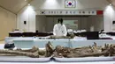 Anggota MND Agency for KIA Recovery and Identification (MAKRI) Korea Selatan menata jenazah tentara China yang tewas dalam Perang Korea di Incheon, Korea Selatan, Rabu (1/9/2021). Korea Selatan memulangkan 109 tentara China yang tewas dalam Perang Korea. (Jeon Heon-kyun/Pool Photo via AP)