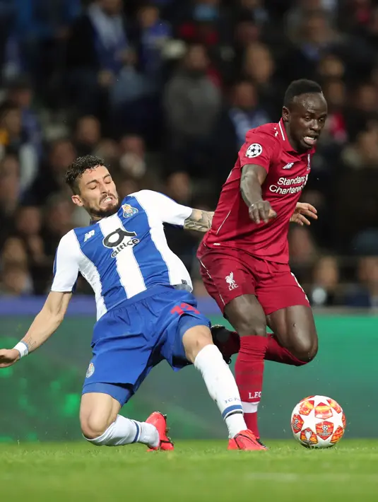 Winger Liverpool, Sadio Mane berebut bola dnegan bek FC Porto, Alex Telles pada leg kedua perempat final Liga Champions 2018/2019 di Estadio do Dragao, Rabu (17/4). Liverpool memastikan lolos ke babak semifinal Liga Champions setelah membantai FC Porto 4-1. (AP Photo/Luis Vieira)