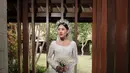 Gaun pengantin Shenina menggabungkan elemen tradisional dan modern dengan sempurna. Detail payet yang cantik menambah kesan elegan pada busana tersebut. Tidak hanya itu, Shenina juga mengenakan mahkota berwarna silver yang membuatnya terlihat seperti putri raja. (Liputan6.com/IG/@sheninacinnamon)