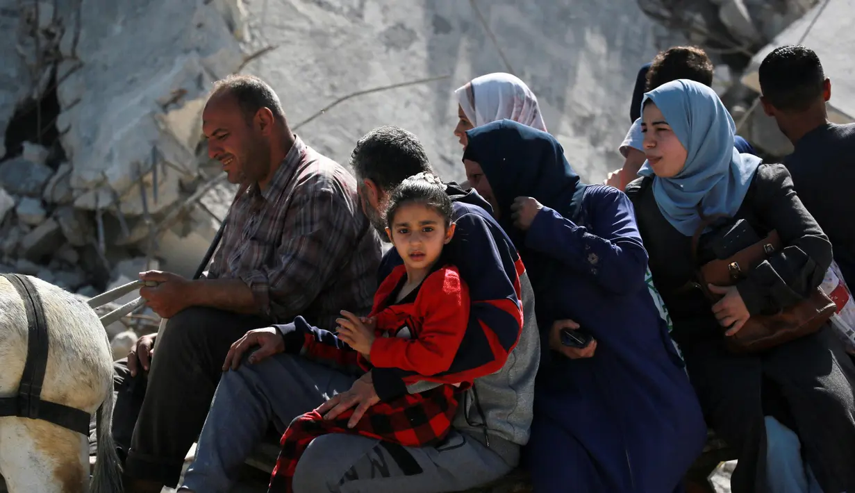 Warga Palestina menaiki gerobak yang ditarik hewan saat meninggalkan Kota Gaza pada 16 Mei 2025. (Bashar TALEB/AFP)