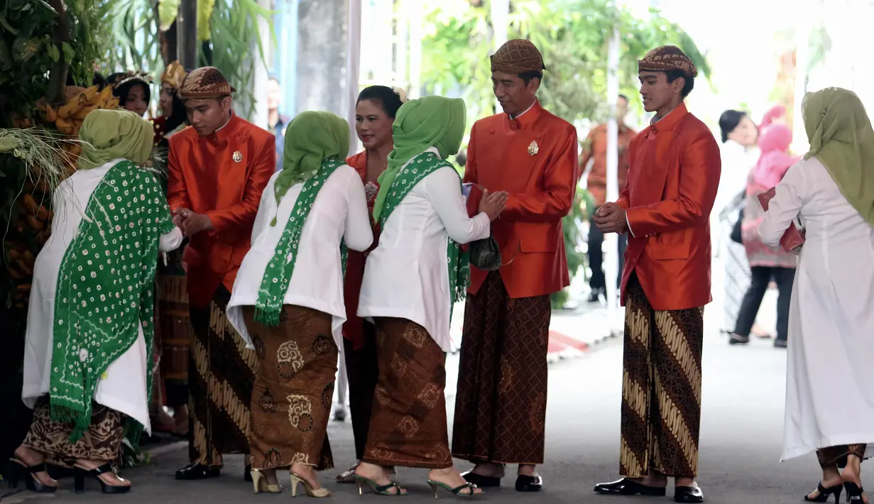 Presiden Joko Widodo (Jokowi) didampingi Ibu Negara, Iriana serta Gibran Rakabuming dan Kaesang Pangarep menyalami tamu yang pulang dari kediamannya di Jalan Kutai Utara, Solo usai prosesi siraman Kahiyang Ayu, Selasa (7/11). (Liputan6.com/Angga Yuniar)
