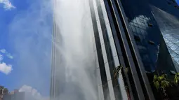 Air terjun buatan di sisi gedung pencakar langit Liebian International Plaza di Kota Guiyang, China, 20 Juli 2018. Air terjun buatan ini menggunakan air hujan dan air tanah yang dikumpulkan dalam tangki bawah tanah berukuran raksasa. (AFP/China OUT)