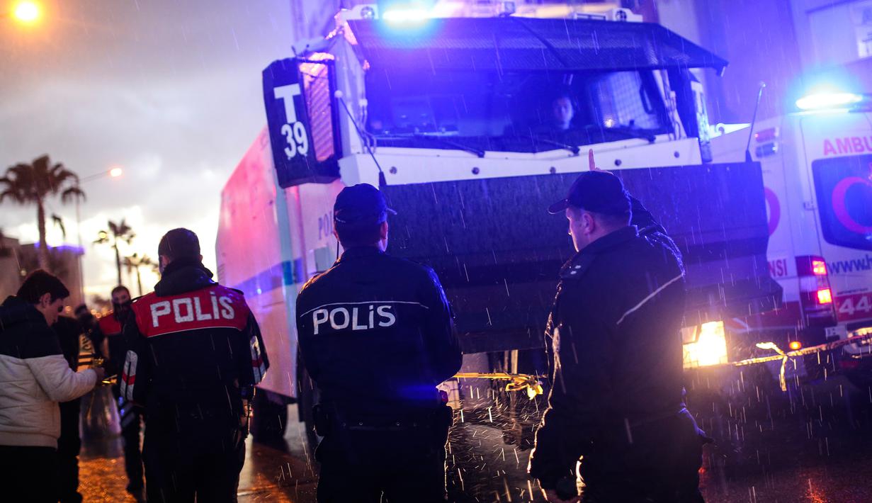 Polisi Turki mengamankan lokasi ledakan sebuah bom mobil yang terjadi di luar sebuah pengadilan di kota Izmir, wilayah barat Turki, Kamis (5/1). Sedikitnya 10 orang terluka akibat kejadian ini. (AFP PHOTO/Emre TAZEGUL)