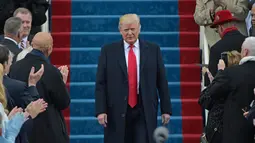 Donald Trump turun menuju podiumnya untuk menyampaikan pidato pertamanya sebagai Presiden AS di Capitol Hill, Washington DC, AS, Jumat (20/1). Dikabarkan, Trump sendiri yang menulis dan menyusun pidato pelantikannya. (AFP Photo)