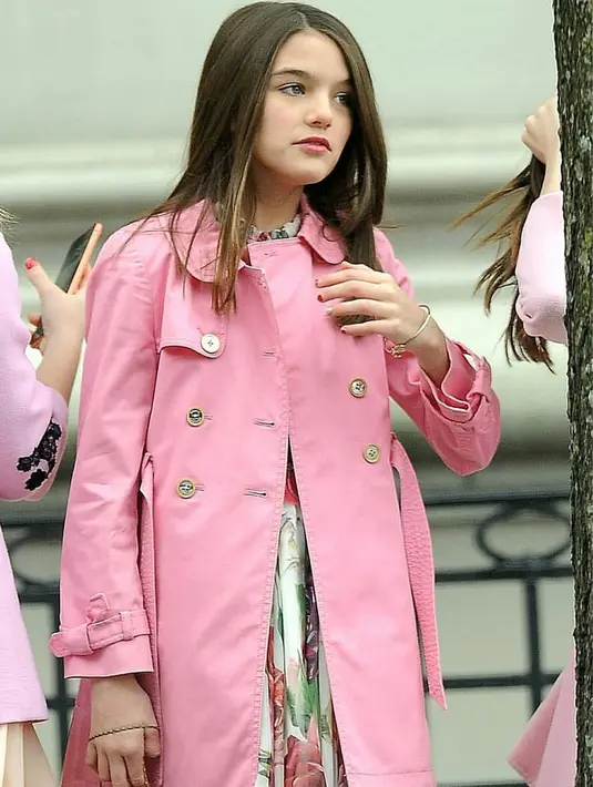 Suri Cruise memakai mantel pink yang dipadukan dengan dress bermotif bunga yang membuat ia tampak lebih modis. (Liputan6.com/IG/@suricruise_fans)