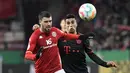 Bek Bayern Muenchen, Joao Cancelo berebut bola dengan bek Mainz 05, Aaron Martin selama pertandingan babak 16 besar Piala Jerman (DFB Pokal) di Mewa Arena, Mainz, Jerman (1/2/2023). MUusim lalu, Cancelo memiliki angka keterlibatan gol yang cukup bagus dalam kapasitasnya sebagai fullback kiri di skema permainan Manchester City. (AFP/Thomas Kienzle)