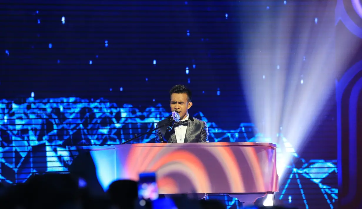 Aksi panggung peserta asal Bau Bau itu tampil penuh penghayatan sambil memainkan Piano saat membawakan lagu milik Rhoma Irama berjudul Kehilangan. Para dewan juri juga memberikan standing ovation. (Adrian Putra/Bintang.com)