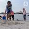 Warga berwisata di Pantai Lagoon, Taman Impian Jaya Ancol, Jakarta, Selasa (13/5/2025). (Liputan6.com/Herman Zakharia)