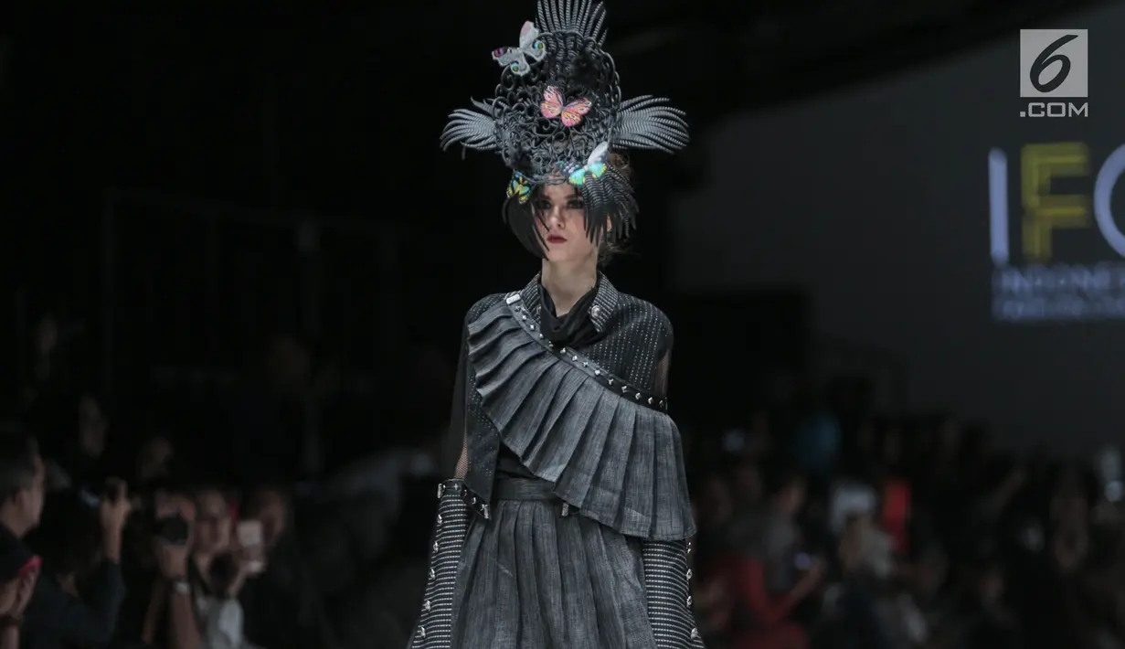 Model mengenakan baju rancangan Agus Sunandar pada ajang Jakarta Fashion Week 2018 di Senayan City, Jakarta, Selasa (24/10). Sebanyak 16 busana itu didominasi warna abu-abu dan hitam yang merupakan simbol dari batu karang. (Liputan6.com/Faizal fanani)