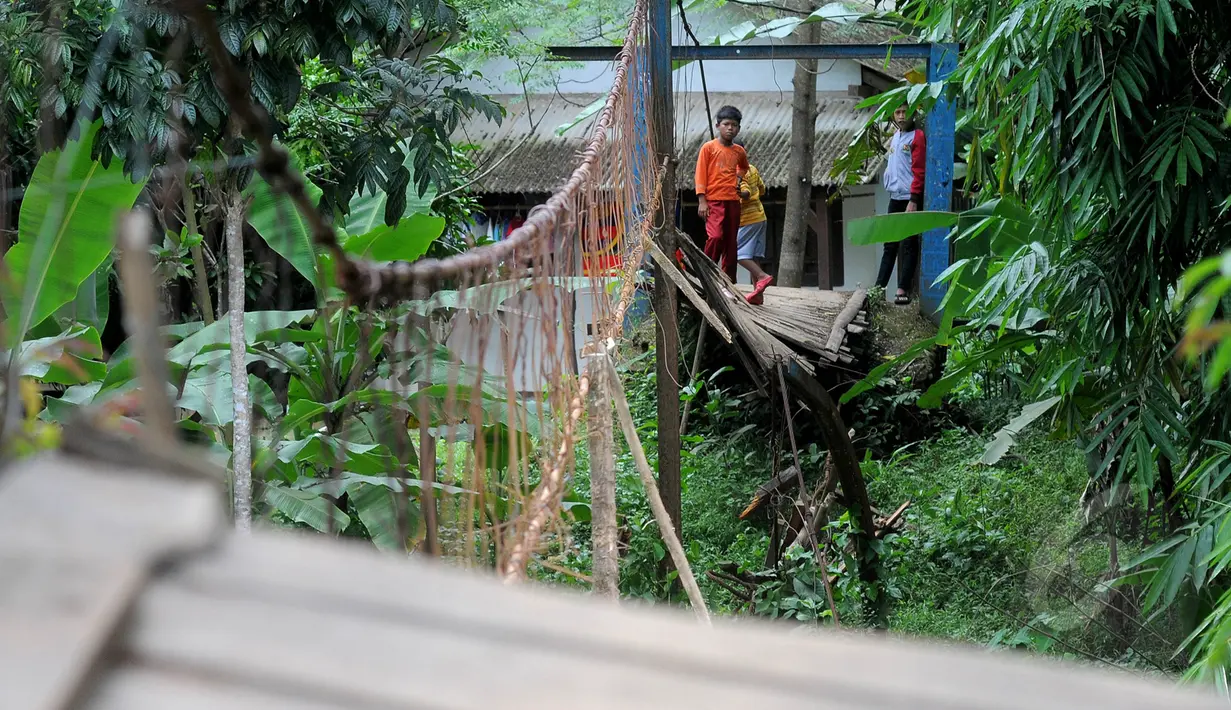 Sejumlah anak melihat lokasi jembatan putus di Lebak, Banten, Senin (16/3/2015). Jembatan yang menghubungkan antara Kecamatan Cimarga dan Kecamatan Sajira, Kabupaten Lebak, putus pada Selasa (10/3) lalu. (Liputan6.com/Herman Zakharia)