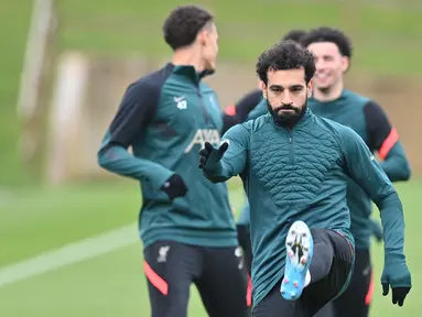 Gelandang Liverpool, Mohamed Salah melakukan pemanasan dalam sesi latihan di tempat latihan Liverpool FC di Liverpool, Inggris (4/4/2022). Liverpool akan bertanding melawan Benfica pada leg pertama perempat final Liga Champions di Estadio Da Luz, Portugal. (AFP/Paul Ellis)