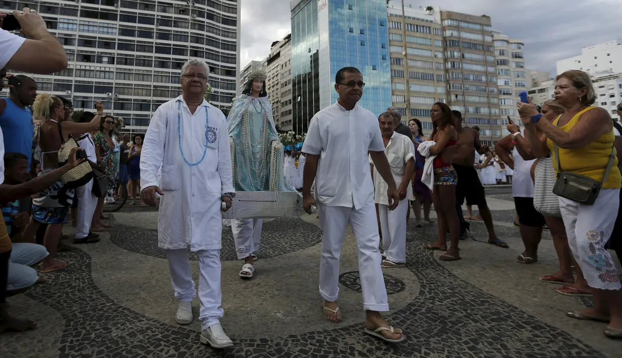 Sejumlah pengikut agama Afro - Brazilian Umbanda membawa persembahan untuk Iemanja, di Pantai Copacabana di Rio de Janeiro, Brasil, (29/12). Iemanja merupakan dewi laut yang dipuja oleh agama tersebut. (REUTERS/Ricardo Moraes)